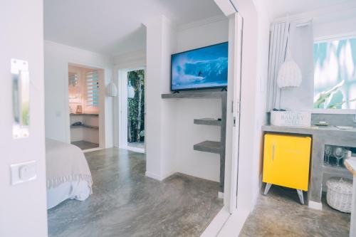 皮帕Cactus Lodge Pipa的一间卧室配有一张床,墙上配有电视