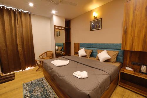 瑞诗凯诗Hotel Mahadev Rishikesh的一间卧室配有一张床,上面有两条毛巾