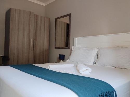 卡萨内Chobe Blue Guest Inn的卧室配有白色的床和蓝色毯子
