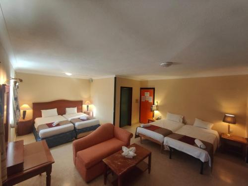 圣朱利安斯The St. George’s Park Hotel的酒店客房,设有两张床和一张沙发