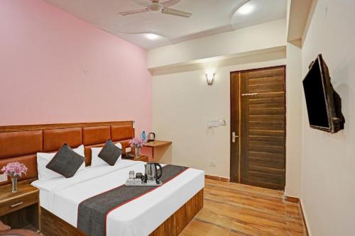 大诺伊达OYO Flagship 74435 Hotel Sharma的一间卧室配有一张大床和电视