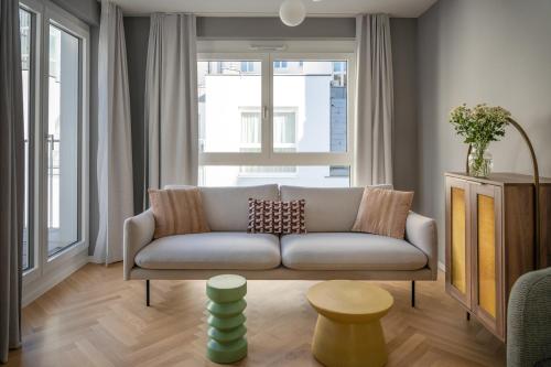 维也纳numa I Terra Apartments的客厅的窗户前设有沙发