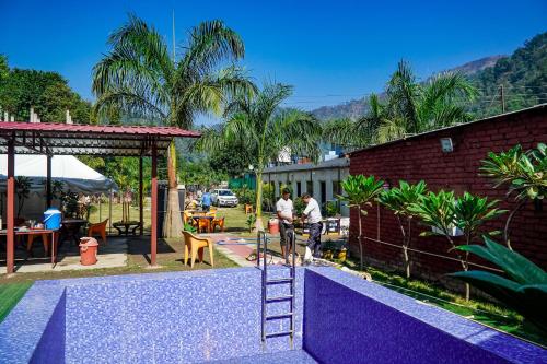 瑞诗凯诗The FnF Resort & Camping - Rishikehs的两人和一个带游乐场的后院梯子
