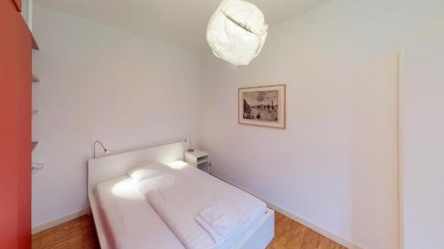 巴塞尔Unique Serviced Living @ Airport Line的白色的房间,配有一张床和墙上的照片