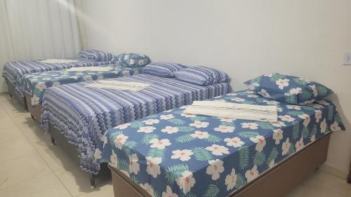 马塞约Suite Pajuçara的配有蓝色棉被的客房内的两张单人床