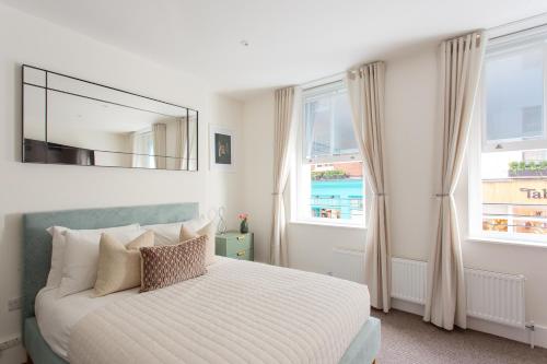伦敦2 Bedroom Apartments in Covent Garden的一间卧室配有一张带镜子和窗户的床