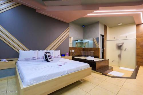 里贝朗普雷托Motel Deslize Ribeirão Preto的一间卧室配有一张大床和一张书桌
