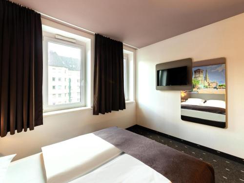 杜塞尔多夫B&B HOTEL Düsseldorf-Mitte的配有一张床和一台平面电视的酒店客房