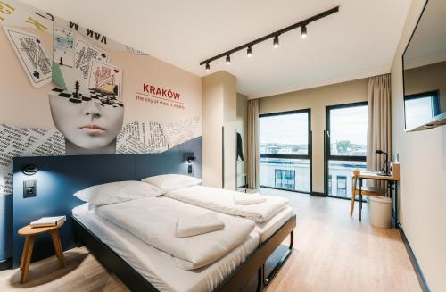 克拉科夫MEININGER Kraków Centrum的一间卧室配有一张大床和床头板