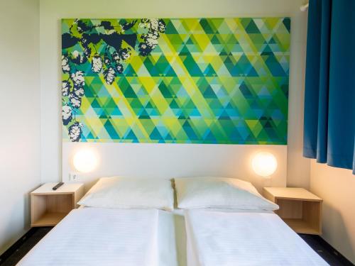 埃朗根埃尔朗根住宿加早餐酒店的墙上画画的房间里设有两张床
