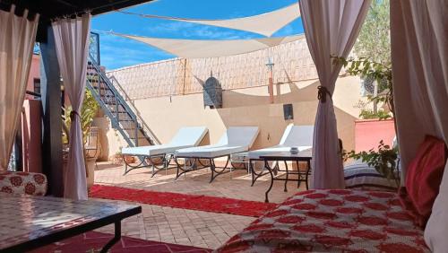 马拉喀什里亚德雨果摩洛哥传统庭院住宅旅馆的一个带桌椅的庭院和楼梯