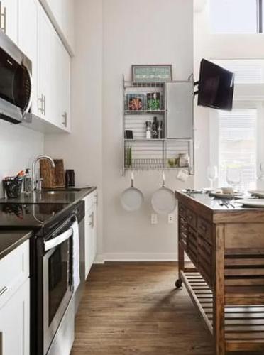 纽约Restful Studio Apartment in NYC!的厨房配有白色橱柜和木制台面