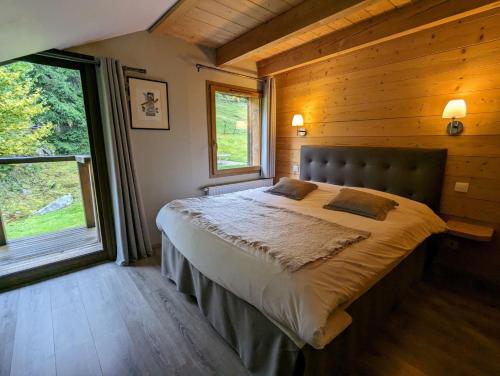 旺特龙La Ferme du Douanier & Spa 5 étoiles ALL INCLUSIVE的小木屋内一间卧室,配有一张大床