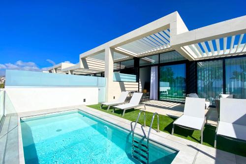阿吉内金海滩Resort Cordial Santa Águeda & Perchel Beach Club的一座带游泳池和房子的别墅