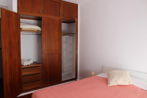 拉戈斯Guesthouse Felicidade的一间卧室配有木制橱柜和一张床