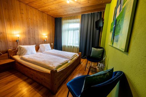 施库尔CURUNA Hotel-Garni的一间卧室配有一张床和两把椅子