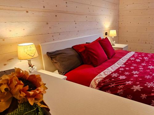 努斯"Rouet" Bilocale a 15 minuti da Aosta VDA-Nus -CIR 0015的一间卧室配有红色枕头的床