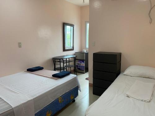达拉盖地Kellocks' Seaview Apartelle的一间卧室配有两张床和一张桌子