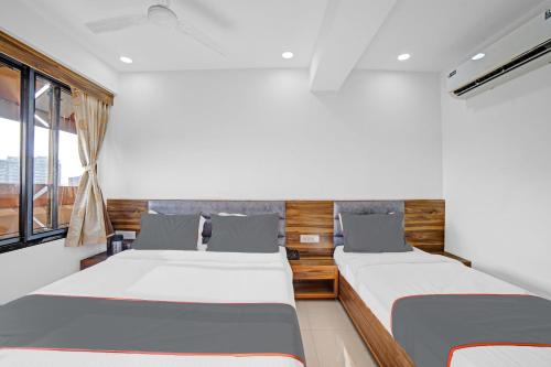 艾哈迈达巴德HOTEL TAPOVAN IN的一间卧室设有两张床和窗户。