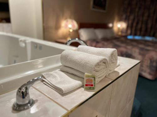 怀特考特Western Budget Motel #3 Whitecourt的一间带毛巾、水槽和床的浴室