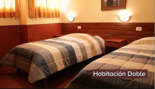ChalhuancaHOTEL ZEGARRA的一间酒店客房,房间内设有两张床