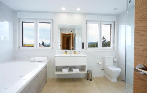 MonteHotel Arias Aeropuerto的白色的浴室设有浴缸、水槽和卫生间。