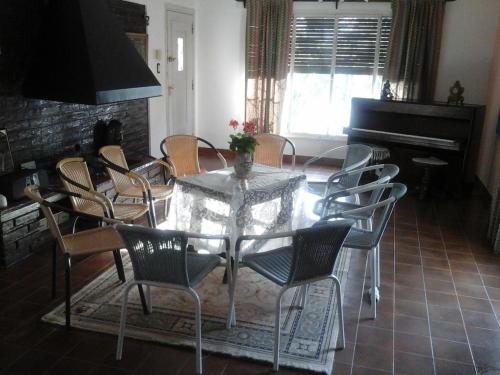 罗卡将军市Casona Antigua的一间带桌椅和钢琴的用餐室