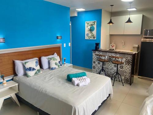 萨夸雷马SUITES VISTA MAR AZUL的蓝色的客房配有一张大床和毛巾