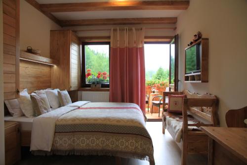 斯祖贝莱克Chata Škerda - Zuberec的一间卧室设有一张床和一个大窗户