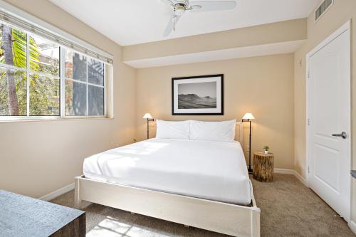 迈阿密Dharma Home Suites South Miami at Red Road Commons的卧室设有一张白色大床和一扇窗户。