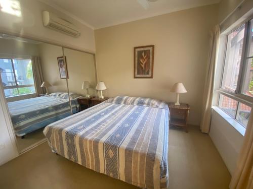 艾吉希尔Lakes Resort 1 Bedroom Apartment的一间卧室设有一张床和两个窗户。