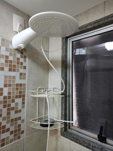 维多利亚Quarto e banheiro privativos com garagem fechada em apartamento aconchegante em Jardim da Penha的墙上设有灯光淋浴的浴室