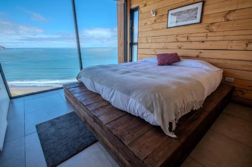 马坦萨斯Quadro Matanzas cabañas的一间卧室设有一张床,享有海景