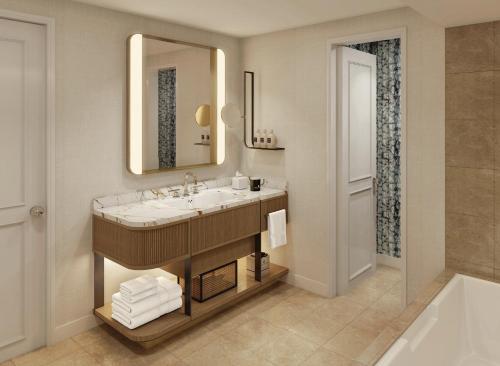 欧文The Ritz-Carlton Dallas, Las Colinas的浴室配有盥洗盆、镜子和浴缸