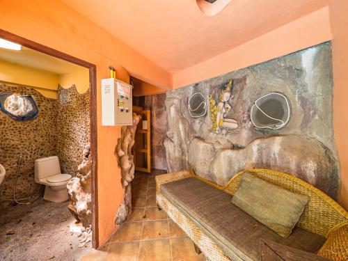 苏梅岛Натуральные виллы в тропическом саду的浴室设有石墙和卫生间