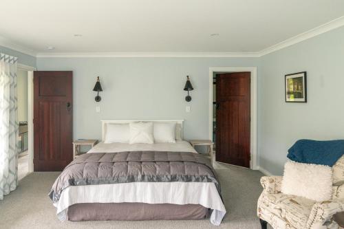 帕拉帕拉乌穆Birdsong Cottage的一间卧室配有一张大床和一把椅子