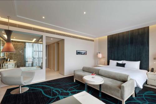 西安Hilton Xi'an High-tech Zone的酒店客房,配有床和沙发