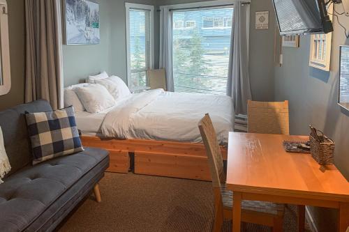 大白山The Lepard's Den - Whitefoot Lodge 206的一间卧室配有一张床、一张桌子和一张沙发