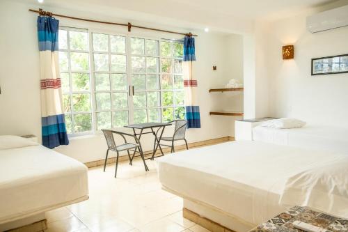 马祖特Casa Mazunte Tierra Viva的一间卧室配有两张床和一张桌子及椅子