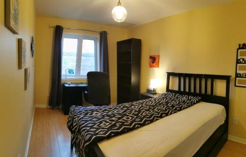 伊魁特Grant Arctic Escape的一间卧室配有一张床、一张书桌和一个窗户。