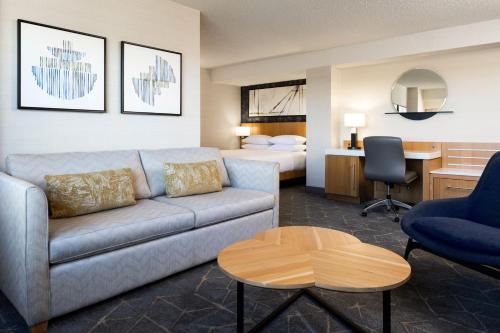 萨斯卡通Delta Hotels by Marriott Saskatoon Downtown的带沙发的客厅和卧室