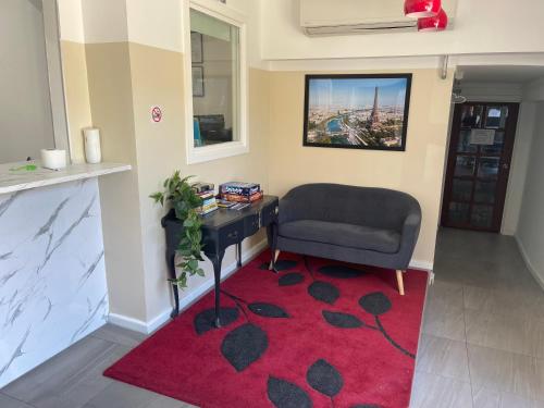 墨尔本St Kilda Accommodation的客厅配有椅子和红色地毯