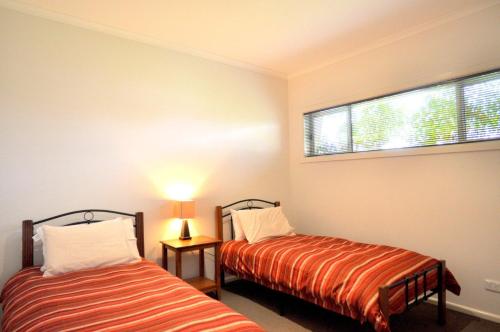 因沃洛什Flying Colours的一间卧室设有两张床和窗户。