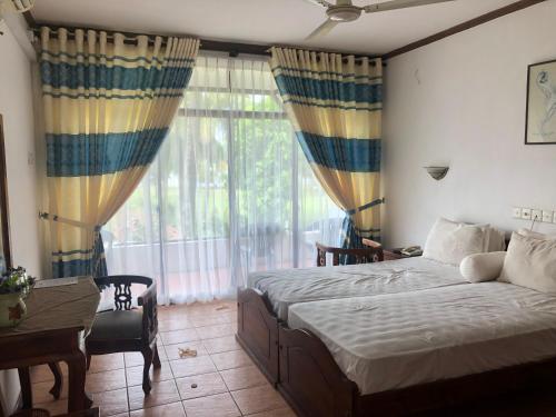 尼甘布Hotel Lagoon Paradise的一间卧室设有一张床和一个大窗户