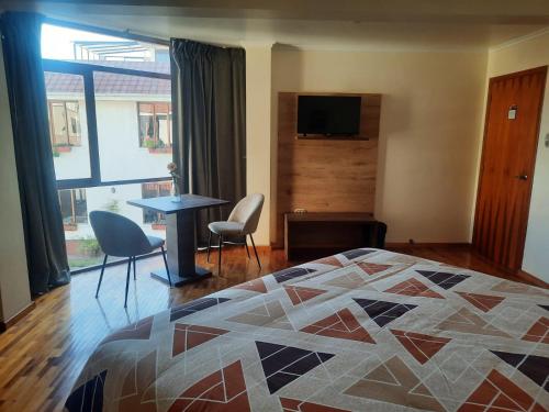 里奥班巴吕康阿莱曼酒店的卧室配有一张床和一张桌子及椅子