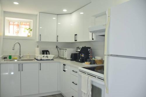 多伦多Entire Basement - 5 Guests 2 Bedrooms 3 Beds的白色的厨房配有白色橱柜和水槽
