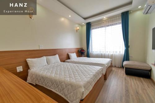 河内HANZ Noi Bai Airport Hotel的酒店客房设有两张床和窗户。