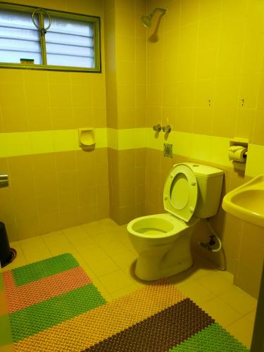 彭亨R2L5Y Room 3 with aircond + TV( share Toilet only)的黄色的浴室设有卫生间和水槽