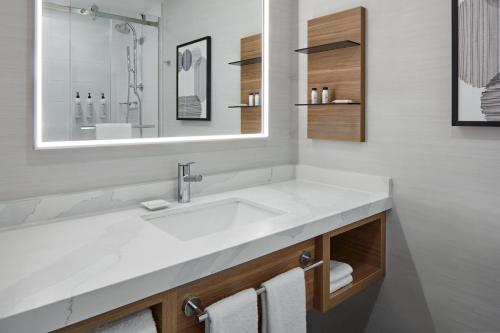 马卡姆Delta Hotels by Marriott Toronto Markham的浴室设有白色水槽和镜子