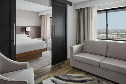 马卡姆Delta Hotels by Marriott Toronto Markham的酒店客房,配有床和沙发